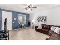 Cozy living room with tile flooring, a ceiling fan, and a comfortable leather sofa at 18147 W Ida Ln, Surprise, AZ 85387