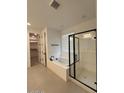 Luxurious bathroom with a soaking tub, glass-enclosed shower, and modern fixtures at 10262 W Columbus Ave, Avondale, AZ 85392