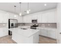Modern kitchen featuring white cabinetry, stainless steel appliances, and a spacious island with pendant lighting at 5338 W Manzanita Dr, Glendale, AZ 85302