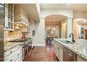 Modern kitchen with stainless steel appliances, granite countertops, white cabinetry, and hardwood flooring at 10050 N 58Th Pl, Paradise Valley, AZ 85253