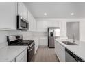 Bright kitchen with stainless steel appliances, white cabinets, and quartz countertops at 12322 W Marguerite Ave, Avondale, AZ 85323