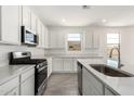 Bright kitchen showcasing white cabinets, stainless steel appliances, quartz counters, and tile flooring at 12326 W Marguerite Ave, Avondale, AZ 85323