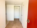 Hallway with neutral color palette, tile flooring, and multiple doors at 10509 W Tropicana Cir, Sun City, AZ 85351