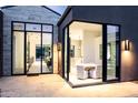Modern dining area with glass doors, sleek lighting, and stylish decor at 6850 E Joshua Tree Ln, Paradise Valley, AZ 85253