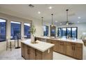 Well-lit open kitchen with large island, modern countertops, and a seamless transition to outdoor living space at 11566 E Christmas Cholla Dr, Scottsdale, AZ 85255