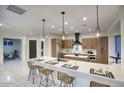 Bright, open kitchen featuring a large island with seating, modern appliances, and stylish pendant lighting at 11566 E Christmas Cholla Dr, Scottsdale, AZ 85255