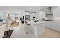 Modern white kitchen boasts a center island, stainless steel appliances, and opens to the living area at 25118 N 171St Ln, Surprise, AZ 85387