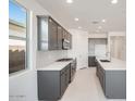 Modern kitchen featuring an island, stainless steel appliances, and stylish gray cabinetry at 25206 N 172Nd Ln, Surprise, AZ 85387