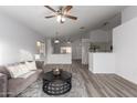 Open living room with vaulted ceiling, hardwood floors, and neutral decor at 1952 N 103Rd Dr, Avondale, AZ 85392