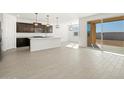 Open concept kitchen with island, stainless steel appliances, and access to backyard at 37501 W San Clemente St, Maricopa, AZ 85138