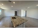 Modern kitchen island featuring granite countertops, stainless steel sink, and ample space for cooking and entertaining at 20542 N 226Th Ln, Surprise, AZ 85387