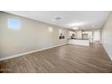 Spacious living room with wood-look tile floors, neutral walls, and plenty of natural light at 20254 W Roma Ave, Litchfield Park, AZ 85340