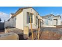 Home exterior showcasing its neutral tones, landscape, and paved driveway under a blue sky at 4430 N 203Rd Dr, Buckeye, AZ 85396