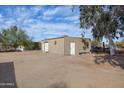 Detached outbuilding featuring multiple access doors and large dirt area around it at 26415 S Recker Rd, Queen Creek, AZ 85142