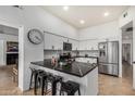 A kitchen features a black marble island with seating, stainless steel appliances, and white cabinets at 11035 E Clinton St, Scottsdale, AZ 85259