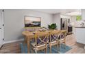 Dining area displays a wood table, place settings, and blue cushions, and adjacent access to the stainless steel kitchen at 2633 W Ocotillo Rd # 3, Phoenix, AZ 85017