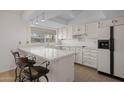 Bright kitchen with quartz counters, tile floors, breakfast bar seating, and white appliances at 1729 Leisure World --, Mesa, AZ 85206