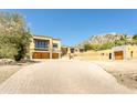 Beautiful home exterior with a charming driveway, mountain views, and attached garages, bathed in sunlight at 7002 N Hillside Dr, Paradise Valley, AZ 85253