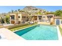 Backyard view featuring a sparkling pool, outdoor seating, and manicured landscaping, perfect for relaxation at 7002 N Hillside Dr, Paradise Valley, AZ 85253