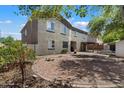 A large backyard features a spacious brick-paved patio, mature trees, and shade with back exterior of the home at 12943 W Mclellan Rd, Glendale, AZ 85307