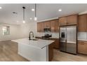 Modern kitchen features stainless appliances, island with pendant lighting, and ample counter space at 2878 N Evergreen St, Buckeye, AZ 85396