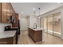 Open kitchen with wood cabinets, center island, stainless appliances, and access to the backyard at 2878 N Evergreen St, Buckeye, AZ 85396