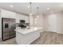 Bright kitchen with stainless steel appliances, a center island, and wood-look flooring at 2888 N Evergreen St, Buckeye, AZ 85396