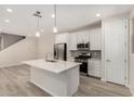 Open kitchen with stainless steel appliances, a center island, and wood-look flooring at 2888 N Evergreen St, Buckeye, AZ 85396