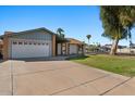 Inviting home with a spacious driveway, two-car garage, and manicured lawn in a quiet neighborhood at 2409 E Hampton Ave, Mesa, AZ 85204