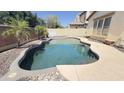 Sparkling backyard pool with stone border and privacy wall, perfect for outdoor entertaining at 15409 W Corrine Dr, Surprise, AZ 85379