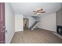 Bright living room with wood floors, ceiling fan, fireplace, and staircase to the second floor at 7977 W Wacker Rd # 174, Peoria, AZ 85381