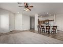 Open-concept living room featuring a breakfast bar and direct access to the kitchen with modern appliances at 26 S Quinn Cir # 7, Mesa, AZ 85206