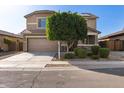 Charming two-story home with mature landscaping, a two-car garage, and a well-manicured lawn at 272 N 167Th Ln, Goodyear, AZ 85338