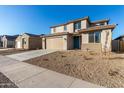 Two-story house with tan exterior, teal door, and landscaped yard at 18424 W Monte Lindo Ln, Surprise, AZ 85387