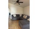Inviting living room with a large sectional sofa and ceiling fan, perfect for relaxation at 12009 W Aster Dr, El Mirage, AZ 85335