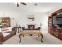 Cozy living room featuring plush carpeting, brown sofas, and decorative wall hangings at 17552 W Young St, Surprise, AZ 85388