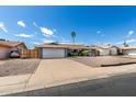 Lovely single-story house featuring a desert landscape and a spacious driveway leading to the attached two-car garage at 3425 W Acoma Dr, Phoenix, AZ 85053