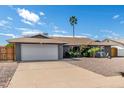 Attractive single-story home showcasing desert landscaping and a wide driveway leading to an attached two-car garage at 3425 W Acoma Dr, Phoenix, AZ 85053