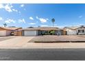 Attractive single-story house showing desert landscape and a wide driveway leading to attached two-car garage at 3425 W Acoma Dr, Phoenix, AZ 85053