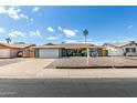 Attractive single-story home with a well-kept lawn, a two-car garage, and a charming seating area in the front yard at 3425 W Acoma Dr, Phoenix, AZ 85053