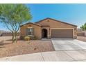 Tan house with brown garage door and landscaping at 25677 W Siesta Way, Buckeye, AZ 85326