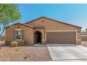 Tan house with brown garage door and landscaping at 25677 W Siesta Way, Buckeye, AZ 85326