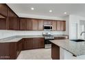 Modern kitchen with granite countertops and dark wood cabinets at 5329 W Rainwater Dr, Laveen, AZ 85339