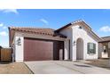 Single-story home featuring a two-car garage, a brown tile roof, stucco walls, and desert landscaping at 7552 W Park St, Laveen, AZ 85339