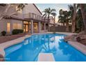 Backyard pool featuring a diving board, rock waterfall and tranquil patio space for outdoor relaxation and entertainment at 760 N Ithica St, Gilbert, AZ 85233