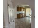 View of the kitchen with wood cabinets, tile floors, and arched doorway leading to other rooms at 4537 E Shomi St, Phoenix, AZ 85044