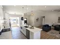 Modern kitchen with island, stainless appliances, and seamless flow into the living area at 4442 E Aire Libre Ave, Phoenix, AZ 85032