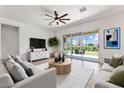 Bright living room with modern furnishings, neutral tones and a large sliding glass door leading to the backyard at 28389 N 131St Dr, Peoria, AZ 85383