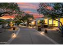 Inviting front yard featuring a water fountain, gravel landscaping, and a curved driveway at dusk at 6620 E Stallion Rd, Paradise Valley, AZ 85253