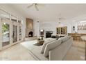 Bright living room with a fireplace, tile floors, ceiling fans, and a wet bar for entertaining guests at 6620 E Stallion Rd, Paradise Valley, AZ 85253